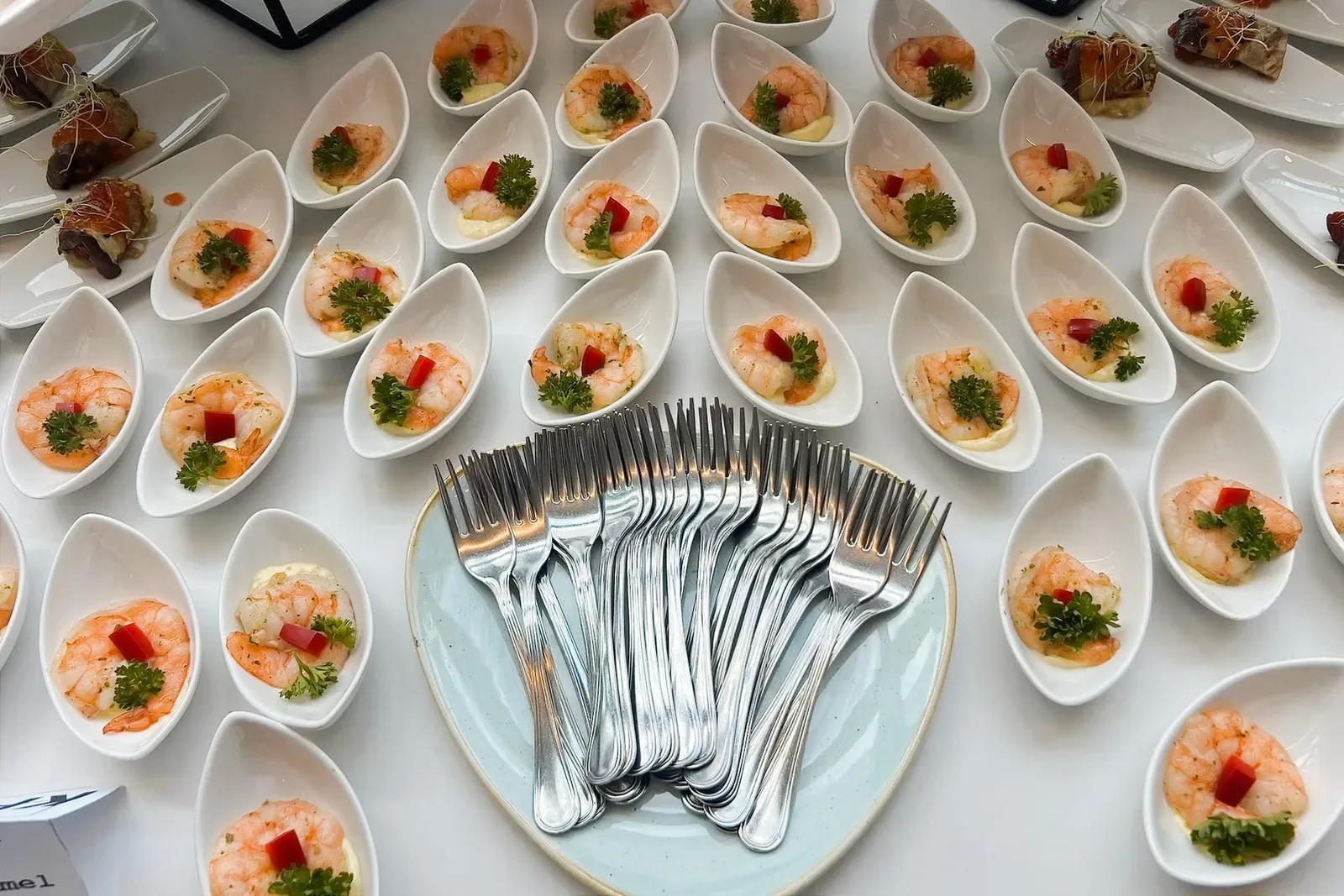 Catering személyzet asztalokat és tálalópultot rendez be egy céges rendezvényen